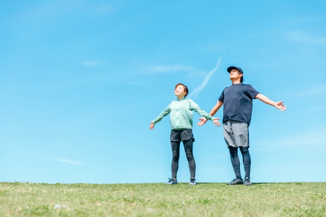 公園で伸びをする男女